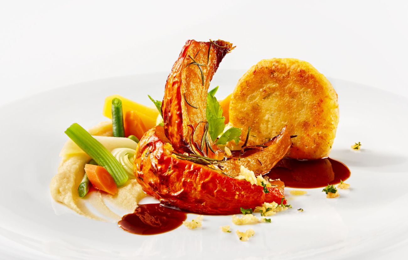 Der vegetarische Hauptgang Geschmorter Kürbis an Pastinakenpüree, glasiertem Wurzelgemüse und Balsamicojus im PALAZZO Berlin.