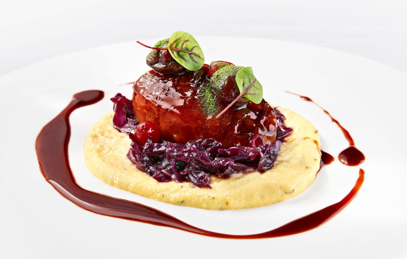 Der vegetarische Hauptgang im Cornelia Poletto PALAZZO Hamburg: „Brasato di Festa“ Geschmorter Knollensellerie mit cremiger Polenta, Balsamico-Apfel-Rotkohl und Maronen.