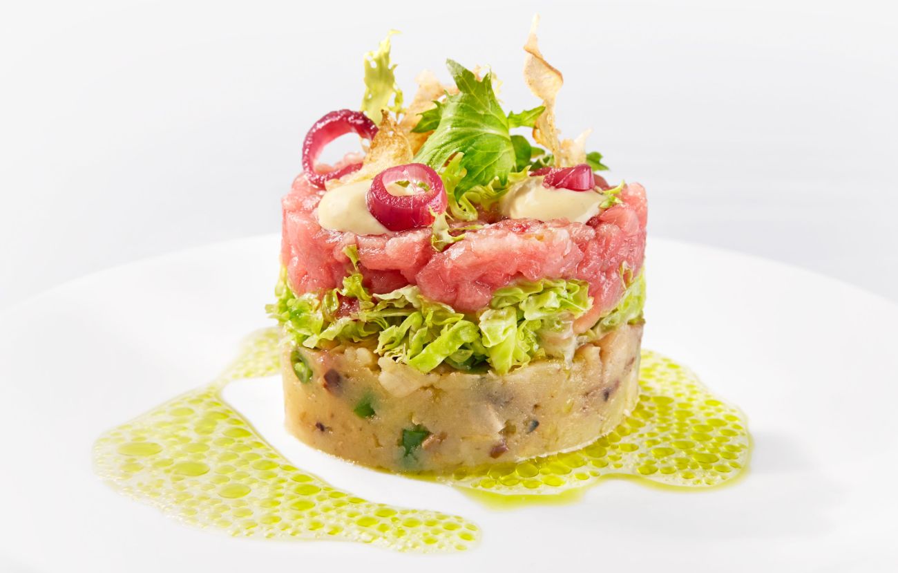 Die Vorspeise im Cornelia Poletto PALAZZO Hamburg: „Tuna“ Insalata nizzarda mit Grenaille-Kartoffeln, Thunfisch-Tatar, Artischocke und Kräutersud.