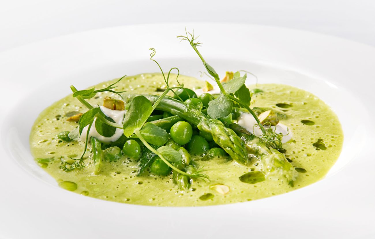 Der Zwischengang im Cornelia Poletto PALAZZO Hamburg: „Es grünt so grün …“ Grüne Minestrone mit Burratacreme, Pistazien und Minzöl.