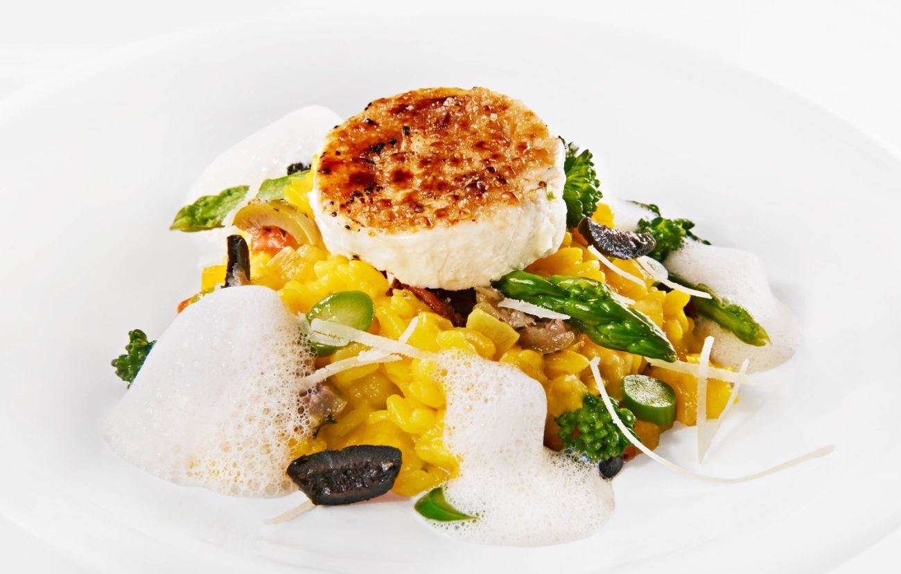 Der vegetarische Zwischengang im PALAZZO Berlin: Risotto von gelber Paprika mit gratiniertem Ziegenkäse, Brokkolini, grünem Spargel und Paprika-Schaum