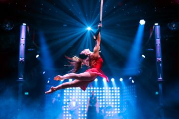 Judit Horvath schwingt im roten Kleid am Tanztrapez im PALAZZO Spiegelpalast.