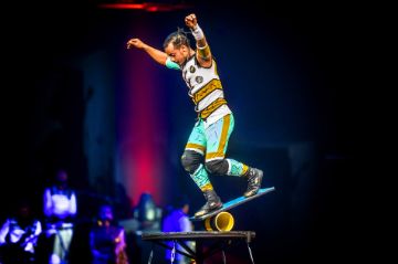 Der Künstler Kedir Siraj balanciert auf einer Rolle bei seinem Rola Bola Act.