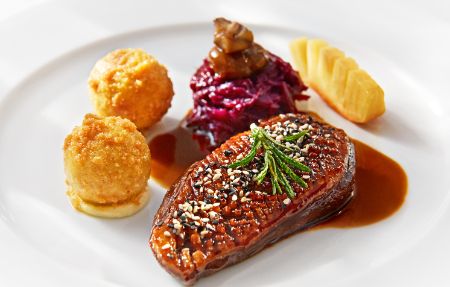 Der Hauptgang im PALAZZO Berlin: Lackierte Entenbrust mit Tannenhonig und schwarzem Pfeffer auf karamellisiertem Rotkohl, dazu kleine Kartoffelknödel und Kardamom-Sauce