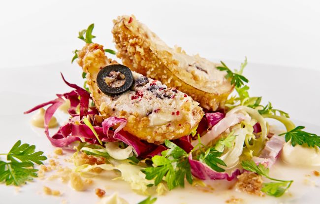 Die Vorspeise im Toni Mörwald PALAZZO Wien: Stracciatella-Pfefferbirne: Williamsbirne – Stracciatella-Creme – Olivencrumble – Radicchio – Dijonmarinade 
