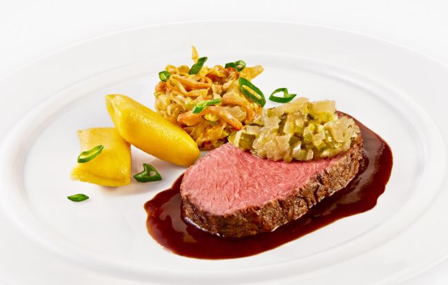 Der Hauptgang im PALAZZO Nürnberg: Rosa gebratener Rinderrücken mit Gewürzjus à la Roulade, Zwiebel-Gurken-Chutney, Senfkraut und Kartoffel-Kräuterkissen