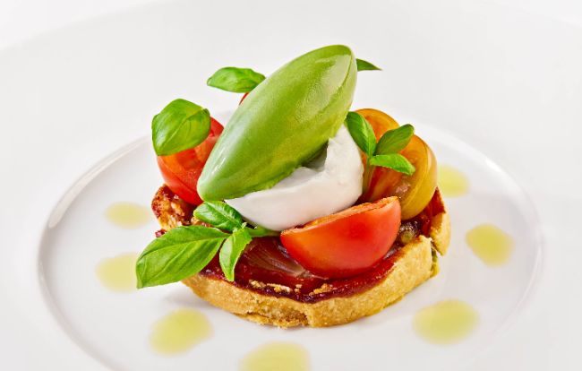Die Vorspeise im PALAZZO Wien: Paradeiser-Schalotten-Tarte Tatin mit Burrata und Zitronen-Basilikum-Sorbet