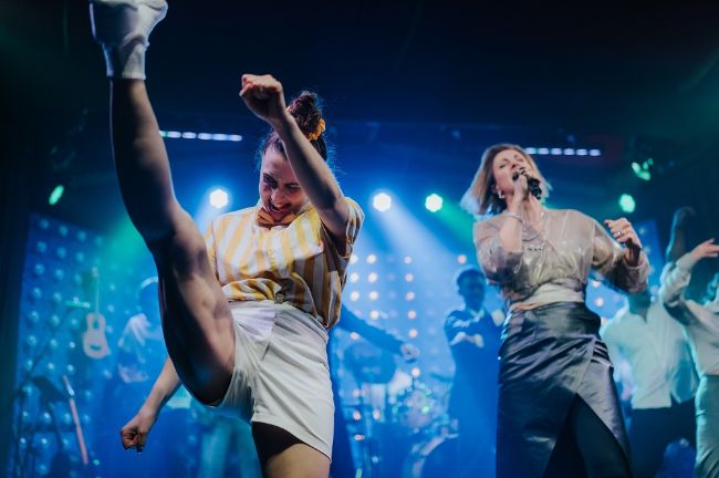 Die Sängerin Sophie Beaudet singt auf der Bühne während Künstler neben ihr tanzen im PALAZZO.