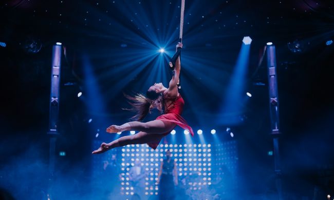Die Künstlerin Judit Horvath schwingt am Trapez im PALAZZO Spiegelpalast.