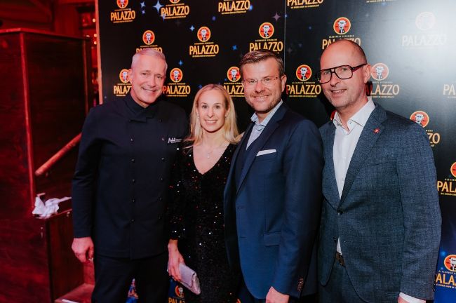 Alexander Herrmann posiert mit Oberbürgermeister Marcus König vor einer Fotowand im PALAZZO Nürnberg.