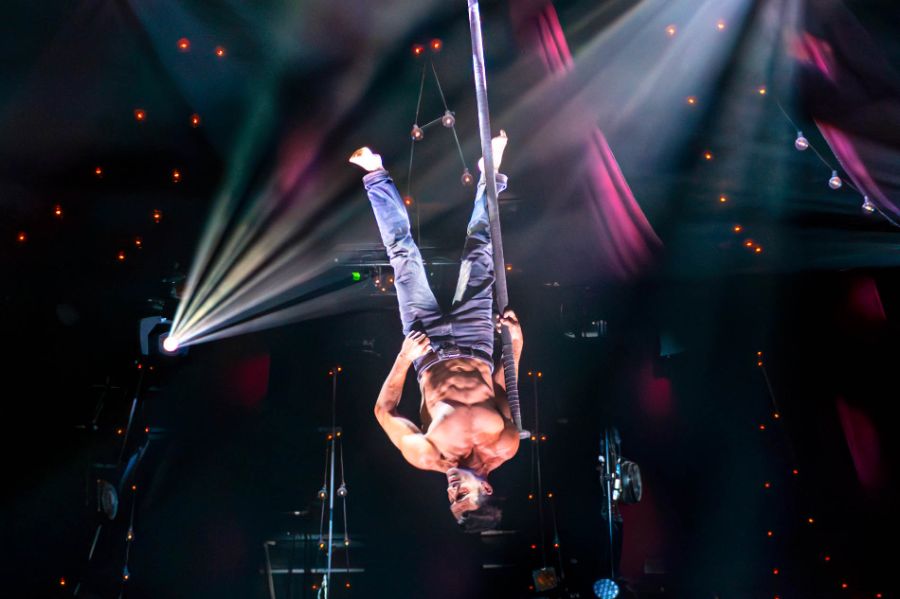 Der Künstler Alberto del Campo hängt kopfüber am Aerial Pole im PALAZZO Spiegelpalast.