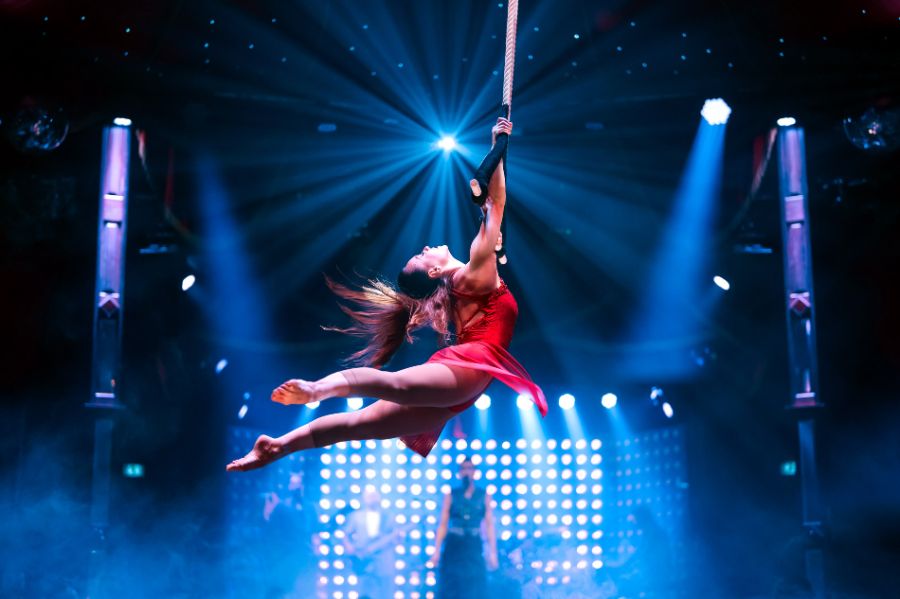Judit Horvath schwingt im roten Kleid am Tanztrapez im PALAZZO Spiegelpalast.